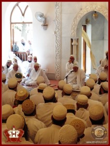 Khuzaima sitting below Syedna Mufaddal at Shz Hatim BS Sadaqallah